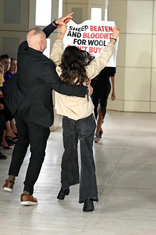 A protester on the runway at the COS fashion show during New York Fashion Week on September 13, 2026.Credit: Getty Images