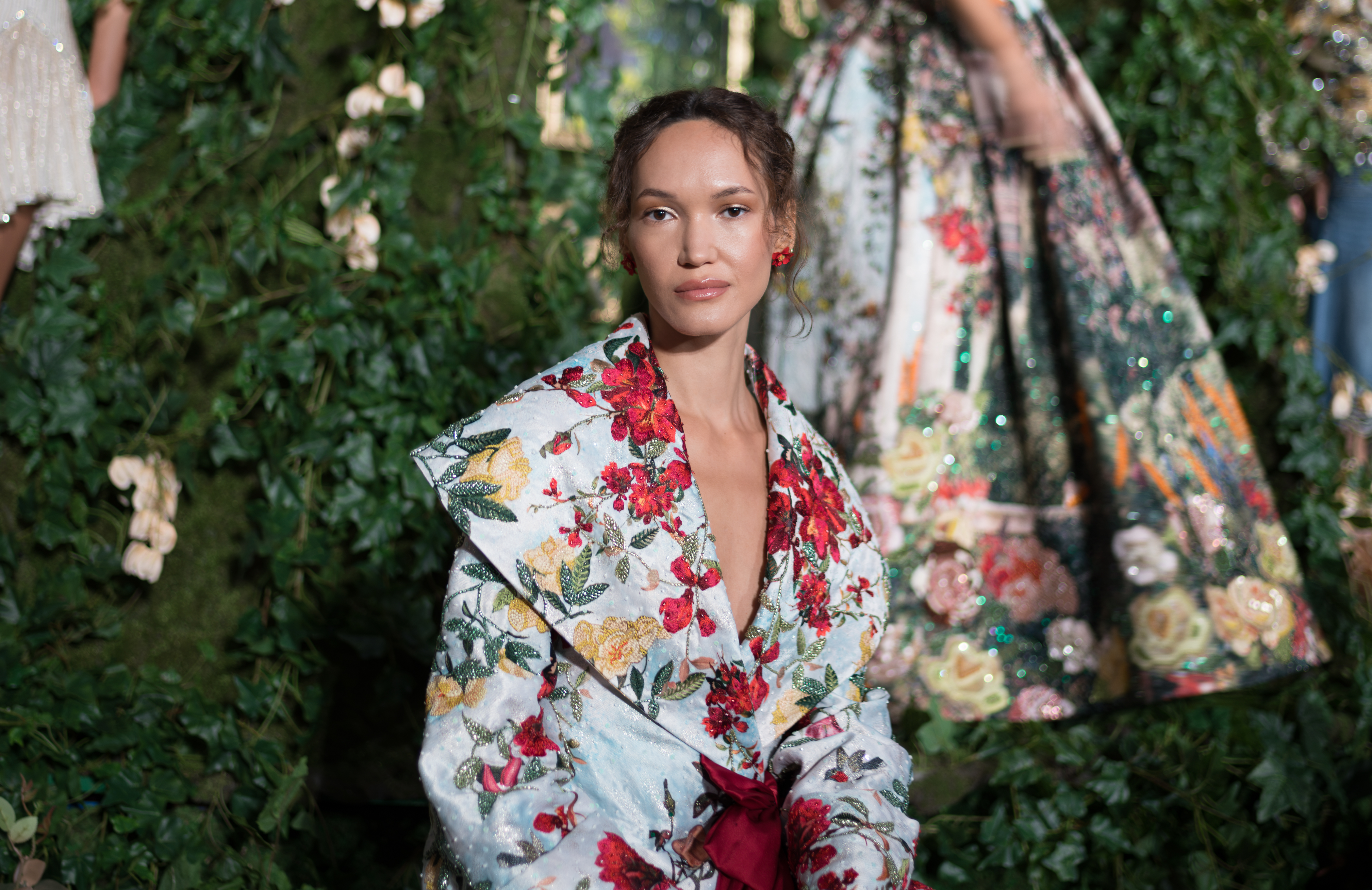 A model in a strapless floral-embroidered coat dress with a burgundy sash at Alice + Olivia's Wonderland presentation.